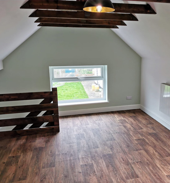 Finished loft conversion room with reclaimed timber balustrade